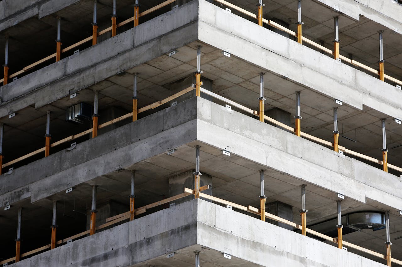 Close-up of an unfinished multi-level concrete building with steel reinforcements.